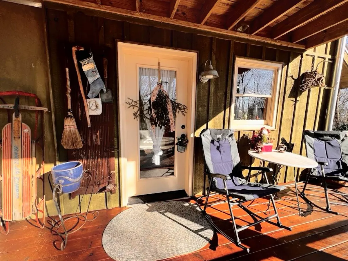 An exterior view featuring the private front door, outdoor chairs, and decorative items on the wall. The cozy outdoor seating and personalized entrance set the tone for privacy and a warm welcome, while seasonal decorations add charm.